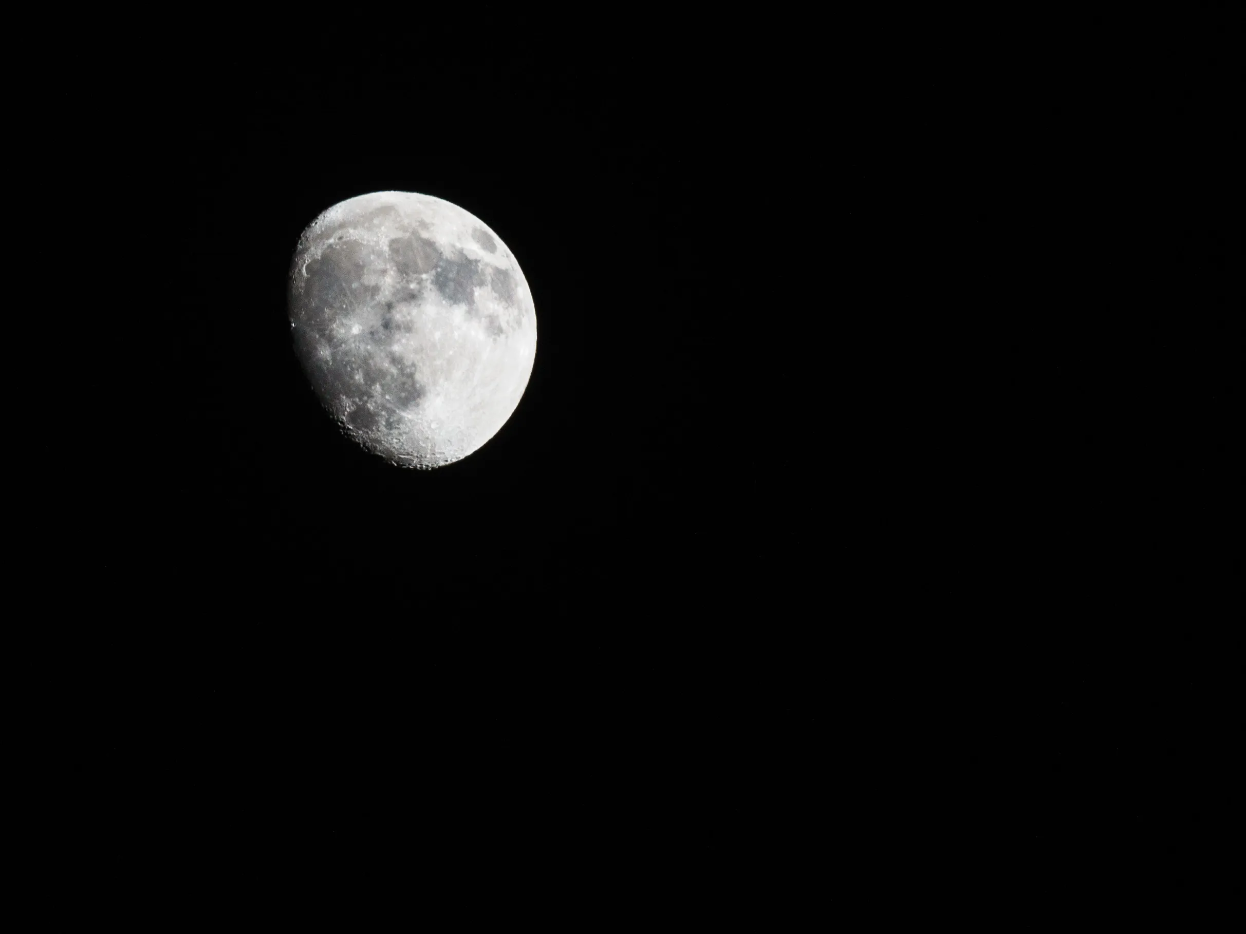 A waxing gibbous moon against a black sky, craters sharp along the terminator