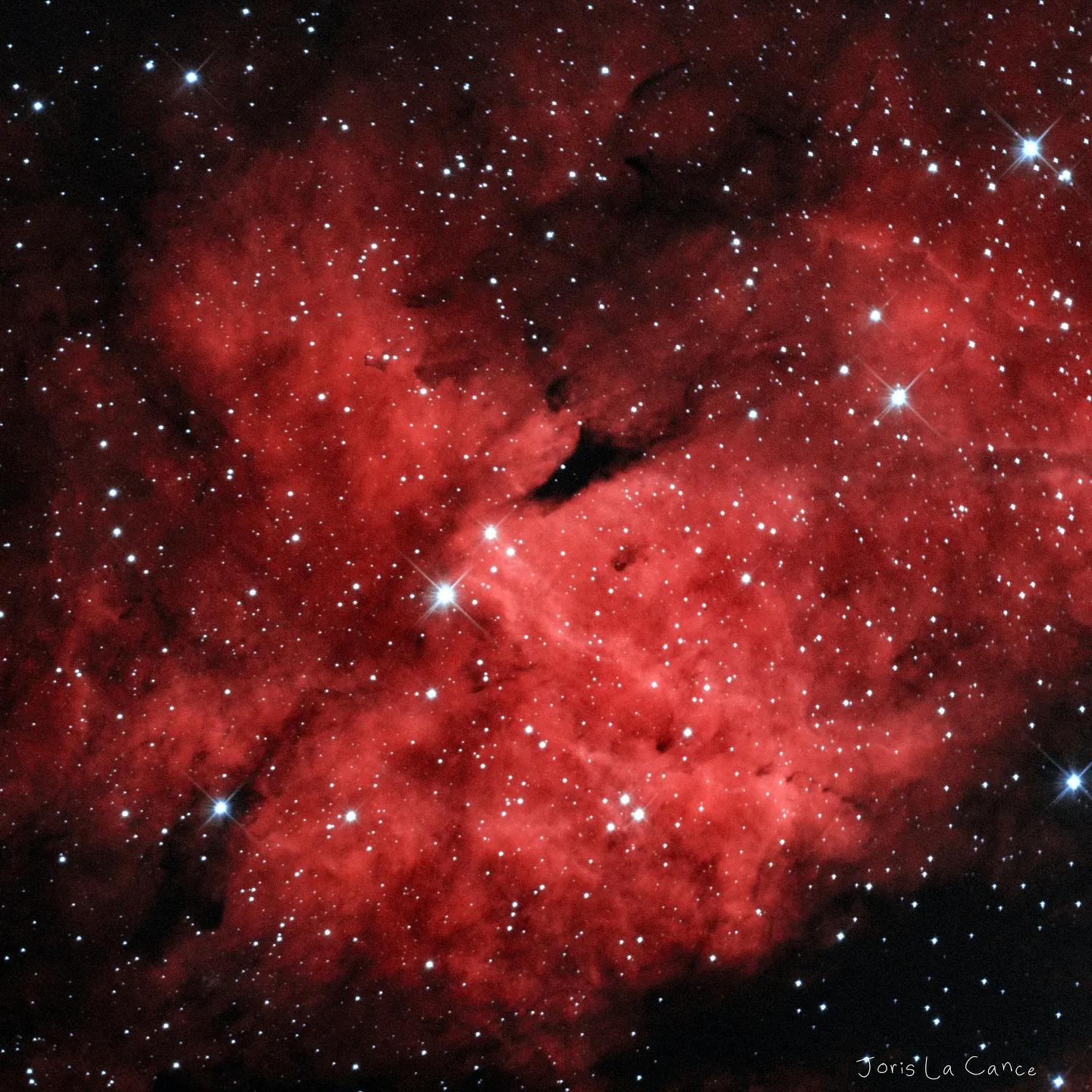 The dark nebula Barnard 347 against the red hydrogen glow of Cygnus
