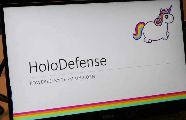 The team's presentation title slide, reading HoloDefense, powered by Team Unicorn, with a rainbow unicorn